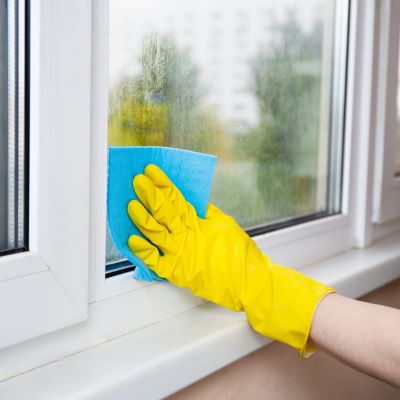 Cleaning A Window With A Spray Bottle And Sponge Cloth